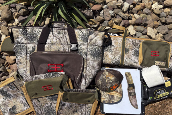 hunting gear essentials - camo bags and accessories on rocks