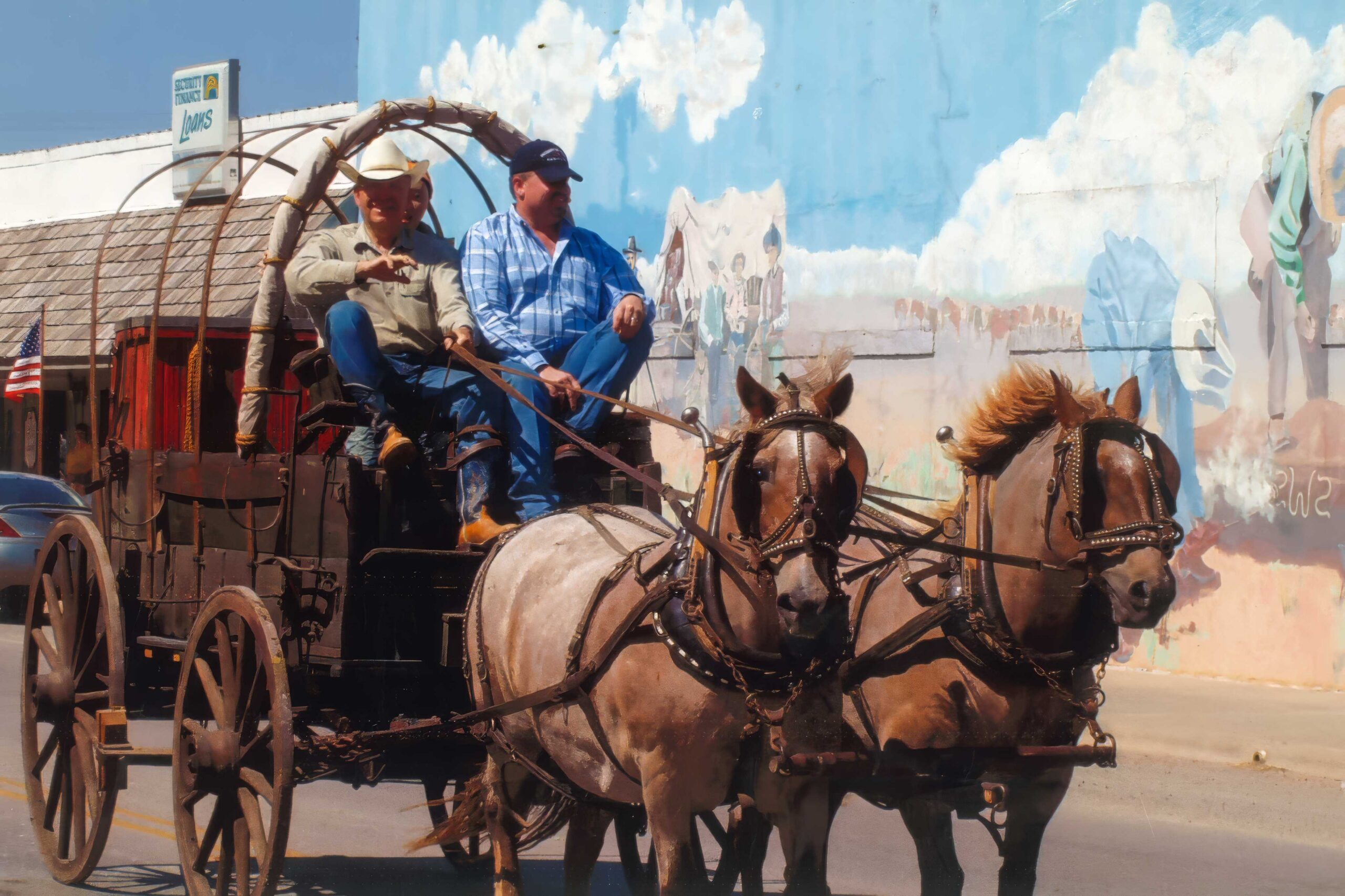Two men riding a horse-drawn chuckwagon
